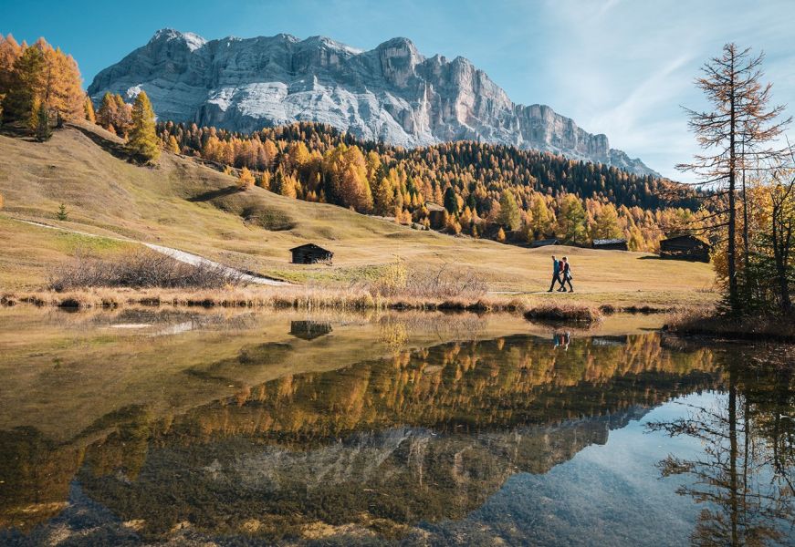 Laghetto alpino con riflesso delle Dolomiti in autunno