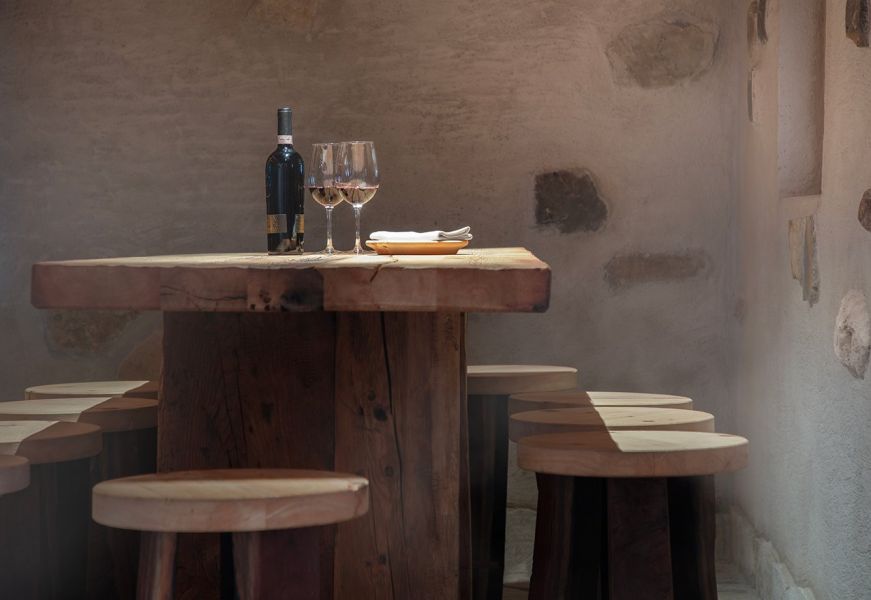 Tavolo rustico in legno con vino rosso e calici nella stube