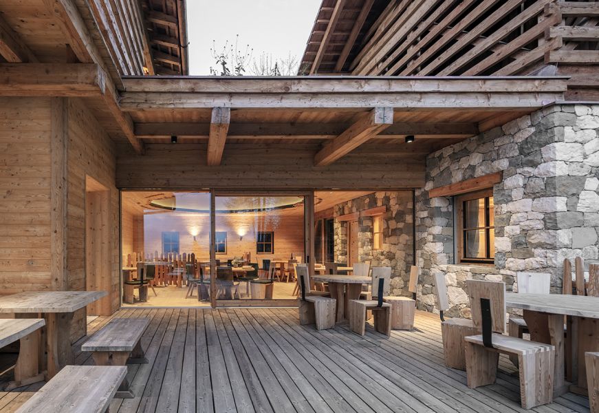 Terrazza in legno del Rifugio Ütia Lé con vista sull'interno